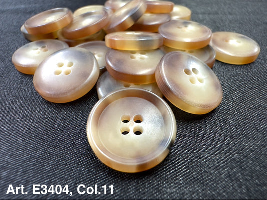 Buttonology Inc four hole sewing buttons pearlescent beige plastic buttons displayed on dark fabric
