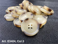 Buttonology Inc beige round buttons with brown rim stacked on dark fabric four hole sewing buttons