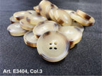 Buttonology Inc beige round buttons with brown rim stacked on dark fabric four hole sewing buttons