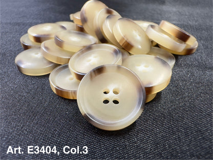 Buttonology Inc beige round buttons with brown rim stacked on dark fabric four hole sewing buttons