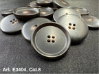 Dark brown round four hole sewing buttons by Buttonology Inc arranged on black fabric matte finish