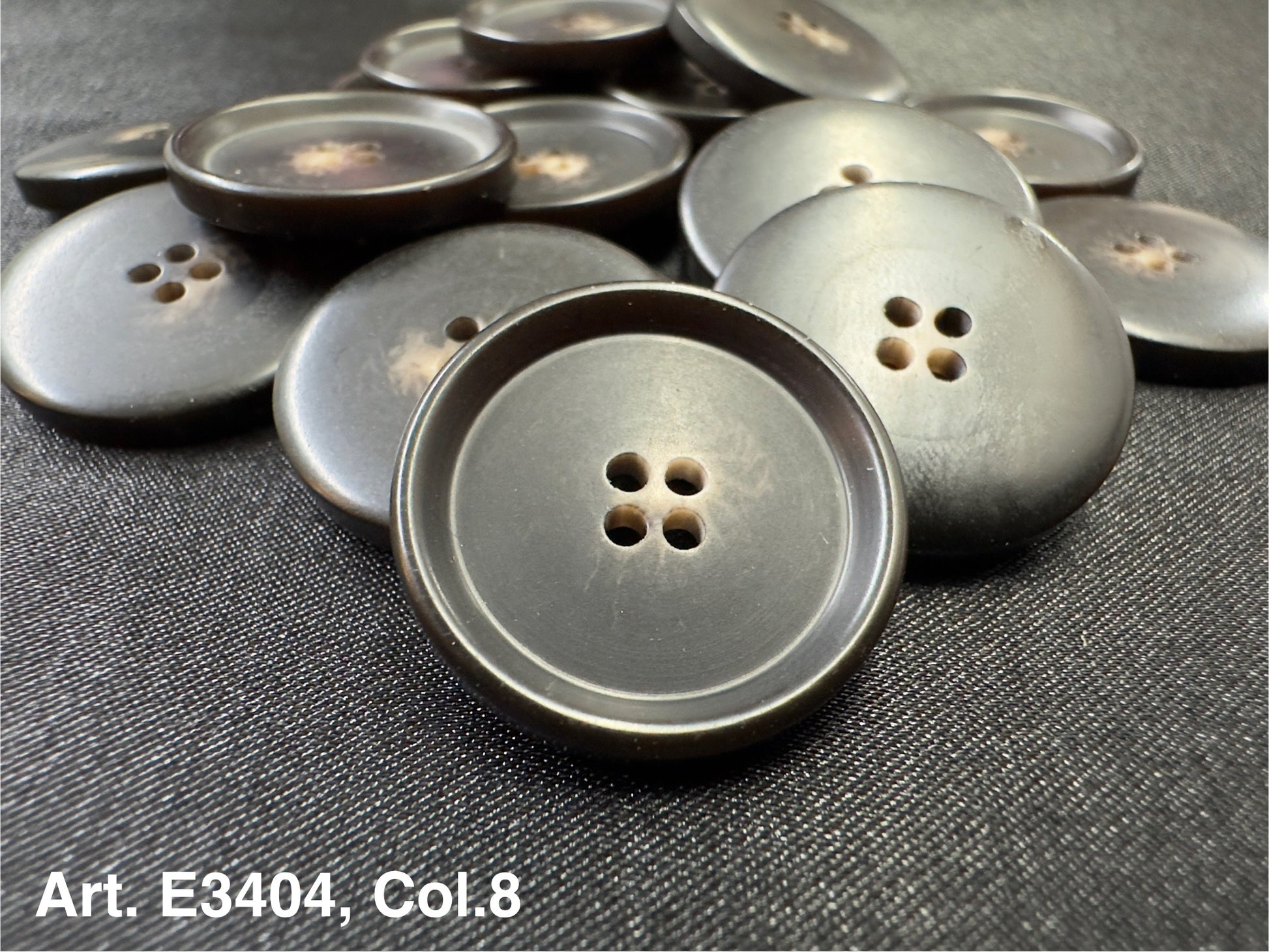 Dark brown round four hole sewing buttons by Buttonology Inc arranged on black fabric matte finish