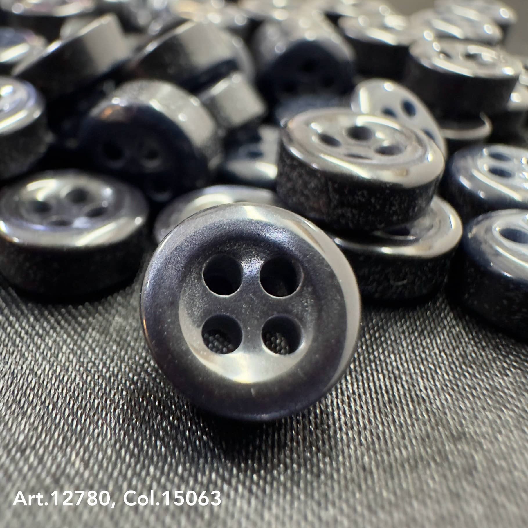 18L four hole plastic buttons with a black glossy finish from Buttonology Inc