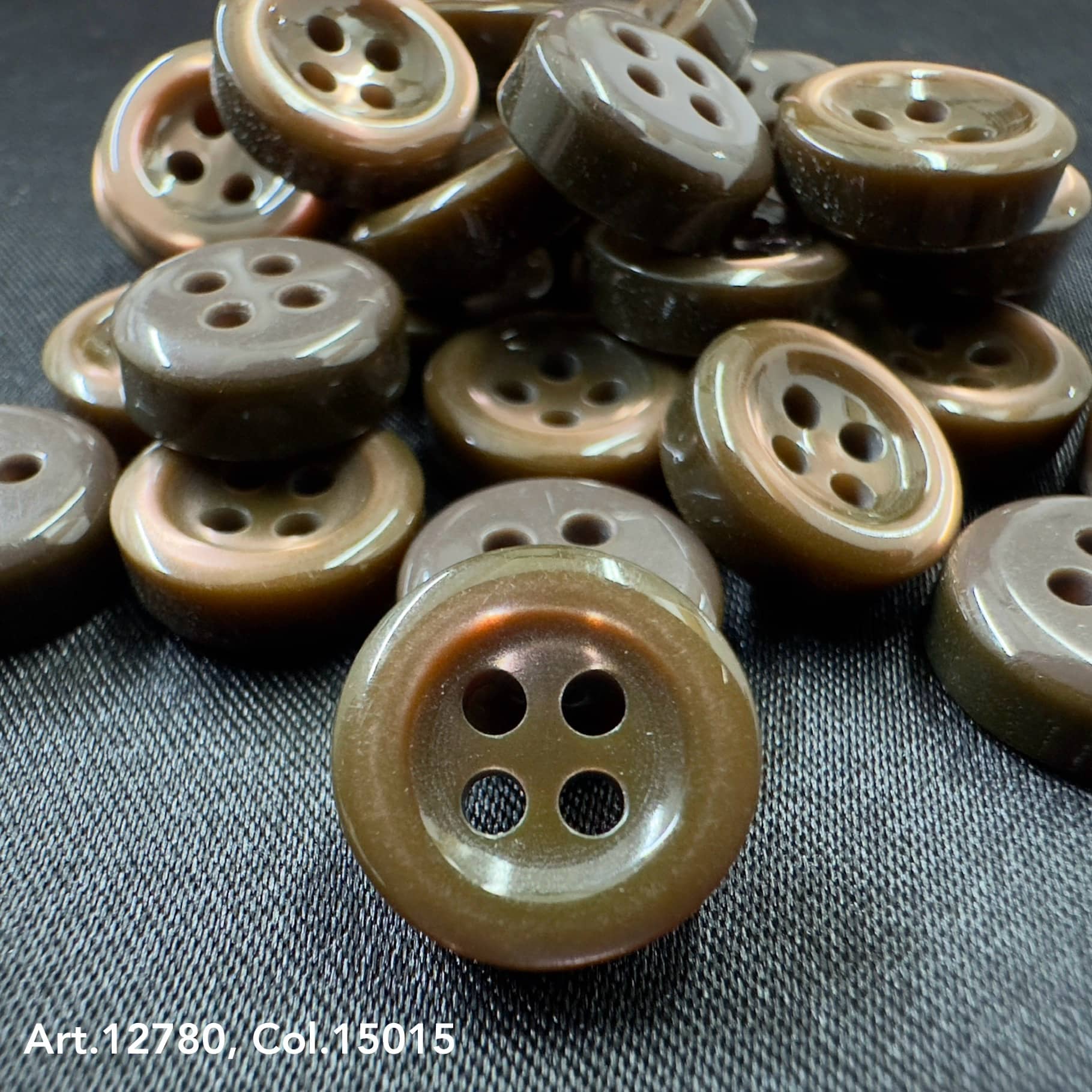 18L four hole plastic buttons in brown by Buttonology Inc on black fabric background