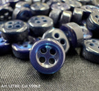Close-up of 18L four hole plastic buttons in dark blue from Buttonology Inc on fabric surface