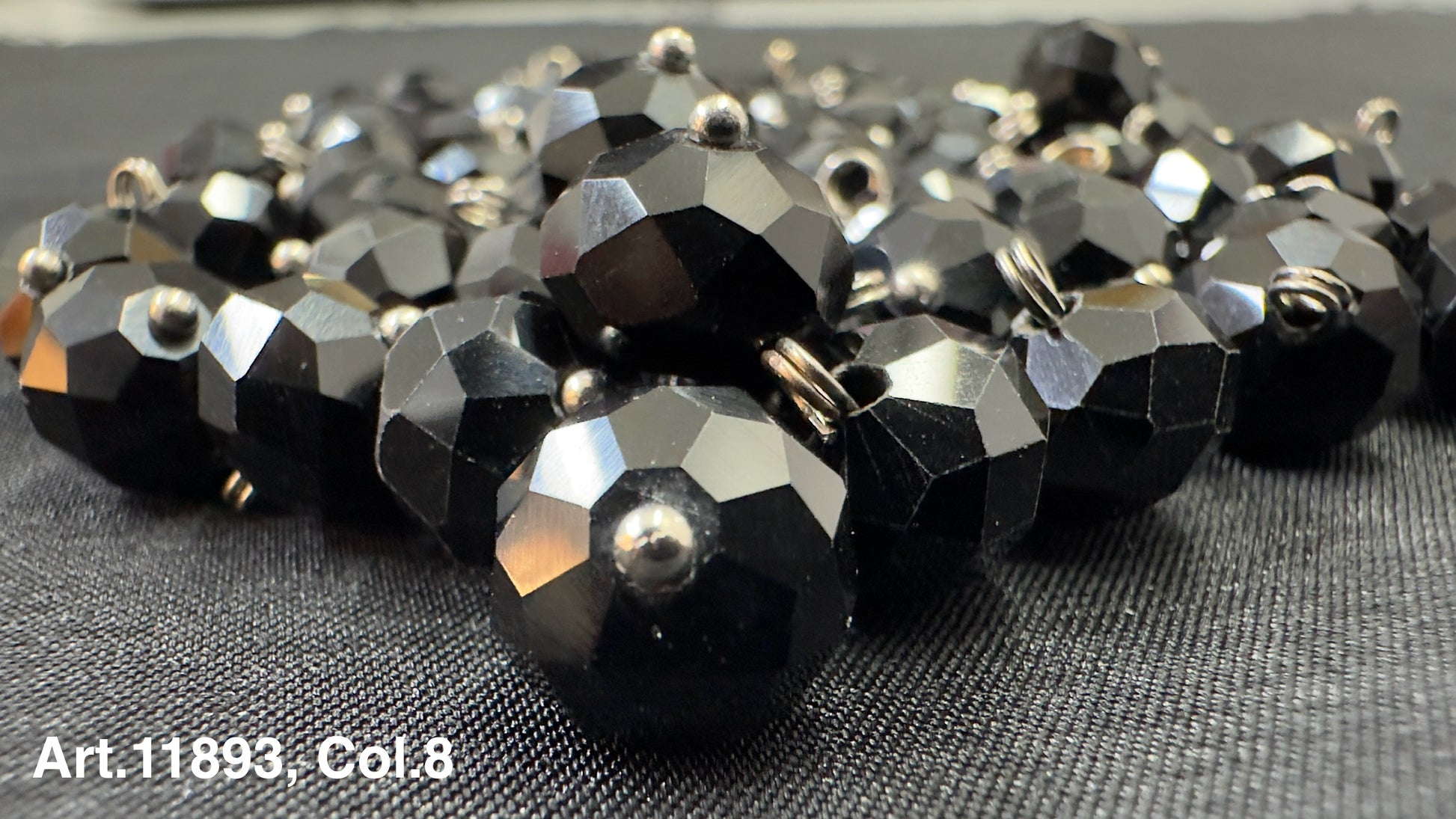 Collection of black glass buttons for sewing featuring a faceted design and shiny finish
