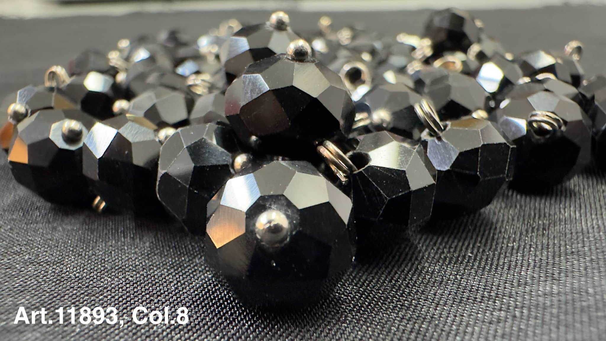Collection of black glass buttons for sewing featuring a faceted design and shiny finish