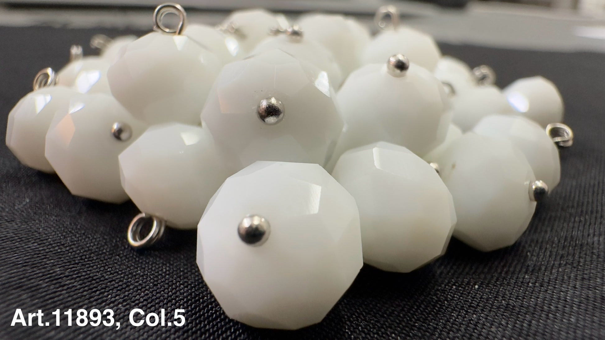 Collection of white glass buttons for sewing with a faceted design from Buttonology Inc.
