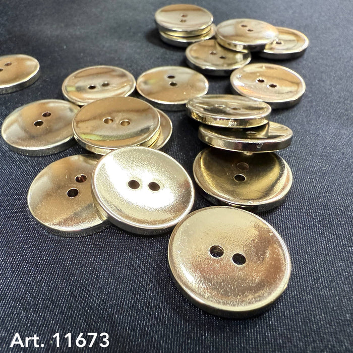 Gold metal buttons from Buttonology Inc scattered on a black fabric background