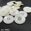 High-quality white buttons from Buttonology Inc scattered on black fabric background