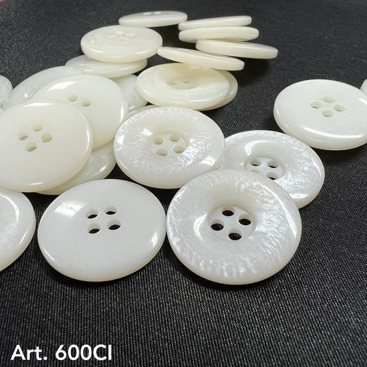 High-quality white buttons from Buttonology Inc scattered on black fabric background