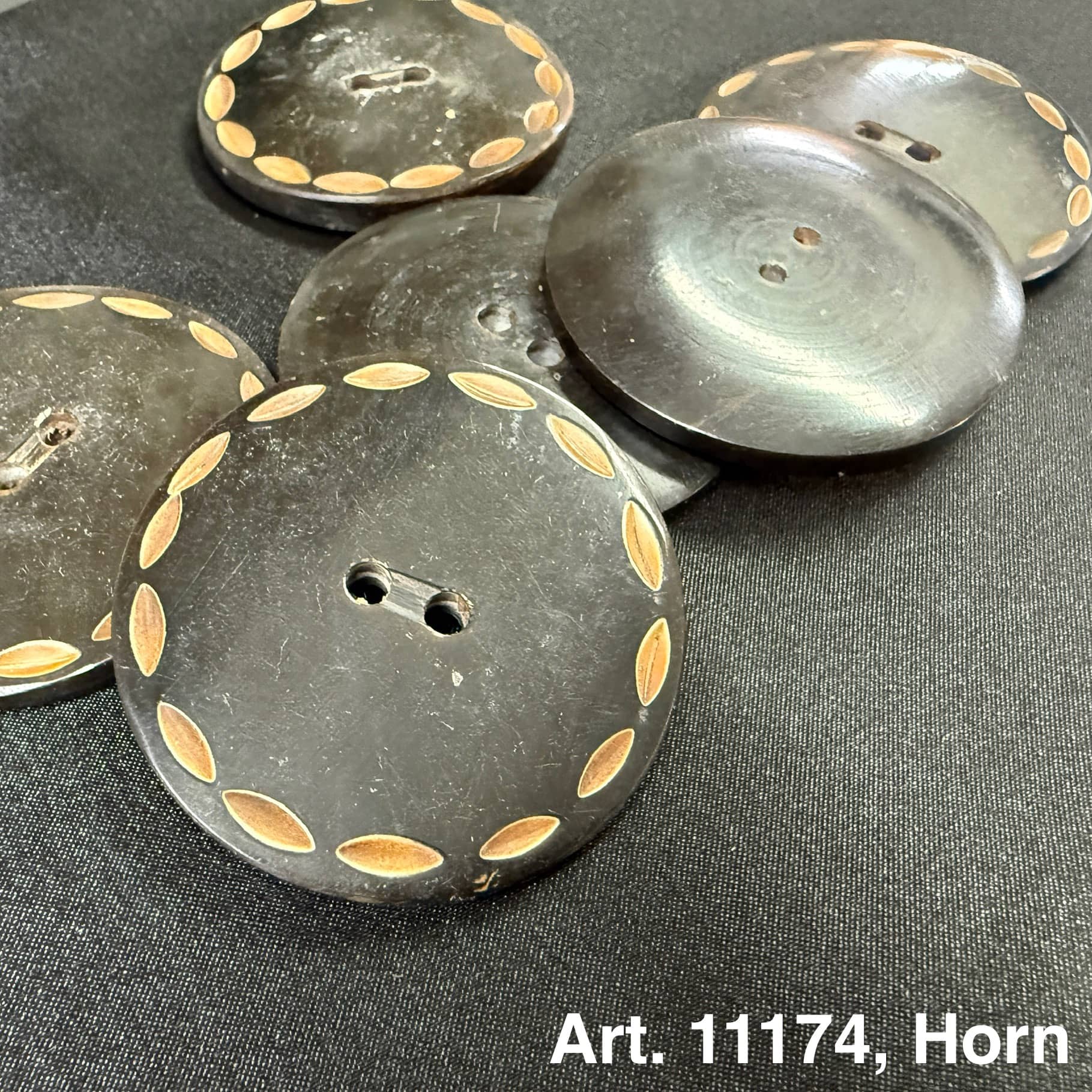 Black decorative horn buttons for garments with carved leaf pattern by Buttonology Inc