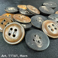 Large horn buttons for coats in brown and black from Buttonology Inc scattered on fabric