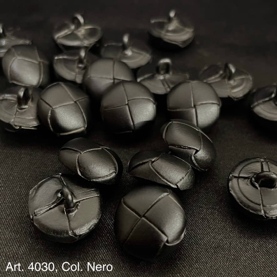 Black leather shank buttons with stitched cross design from Buttonology Inc on black fabric