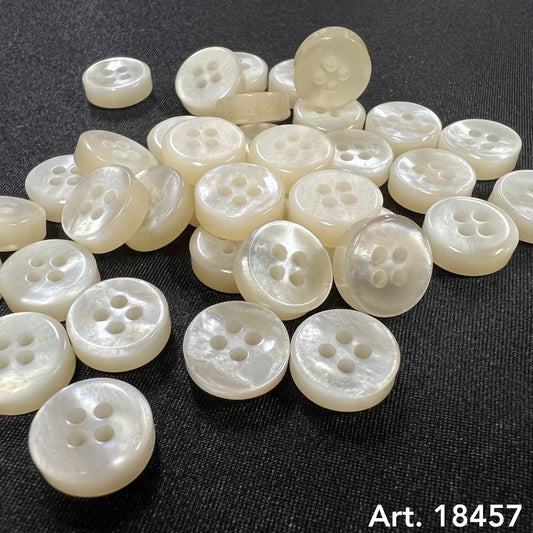 Luxury button designs by Buttonology Inc featuring elegant pearly white four-hole buttons on black fabric