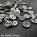 Buttonology Inc smoke marbled round 2-hole plastic buttons for DIY projects scattered on black fabric
