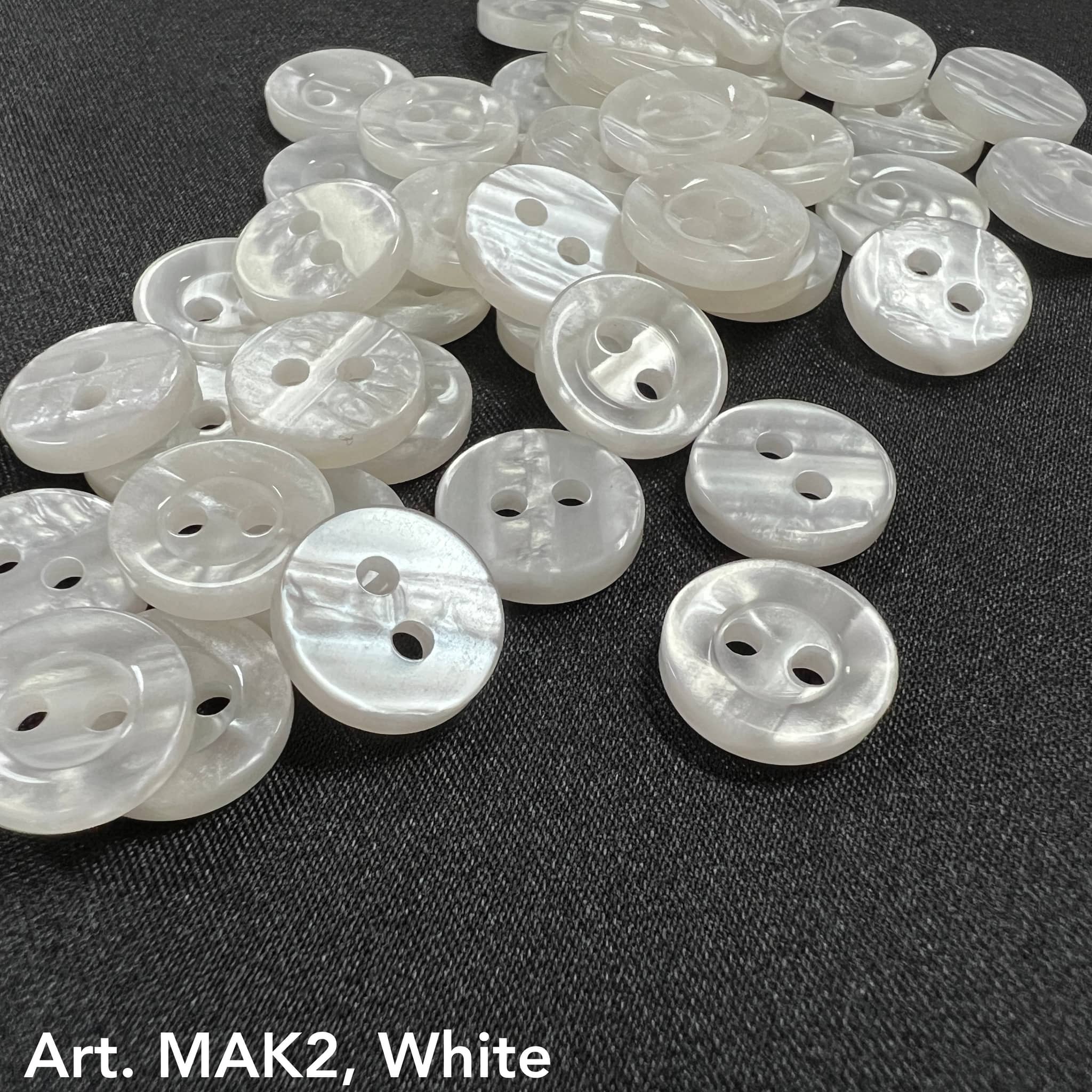 Buttonology Inc white pearlescent 2-hole plastic buttons for DIY projects on dark fabric