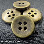 Antique brass metal buttons for clothes with four holes on textured fabric background