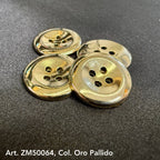 Shiny gold metal buttons for clothing with four holes arranged on black fabric background