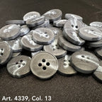 Gray plastic buttons sewing buttons with four holes stacked on black fabric by Buttonology Inc