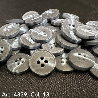 Gray plastic buttons sewing buttons with four holes stacked on black fabric by Buttonology Inc