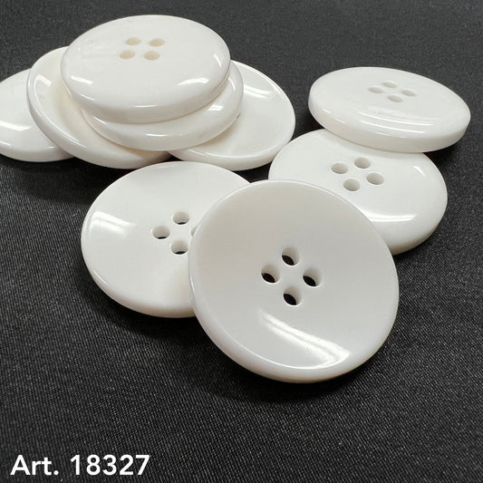 White plastic sewing buttons with four holes from Buttonology Inc. displayed on black fabric