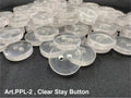 Buttonology Inc clear stay button 2-hole translucent round sewing buttons piled on black fabric