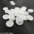 White buttons from the premium button collection by Buttonology Inc spread on dark fabric background