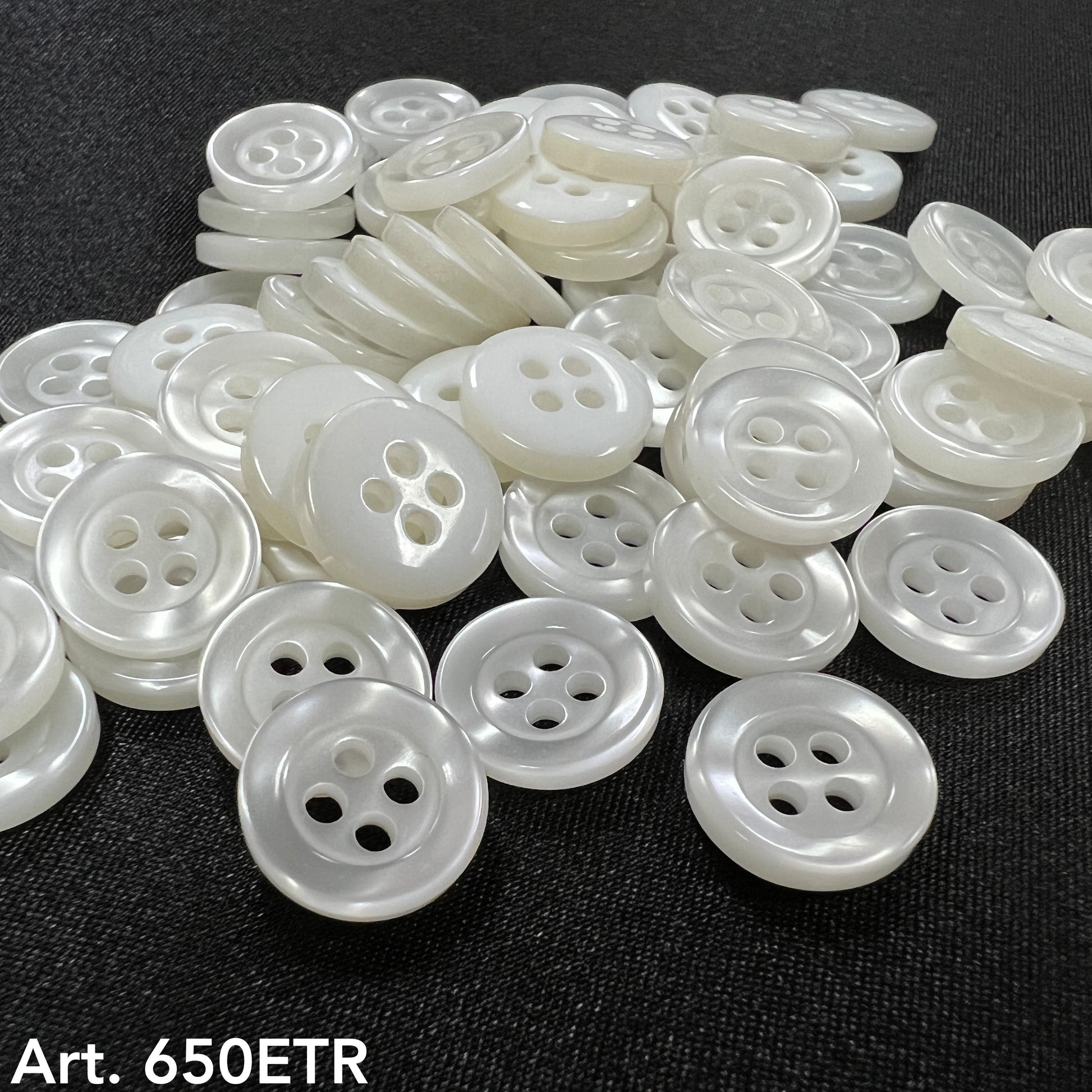 Premium garment buttons for clothes white round buttons with four holes on black fabric background