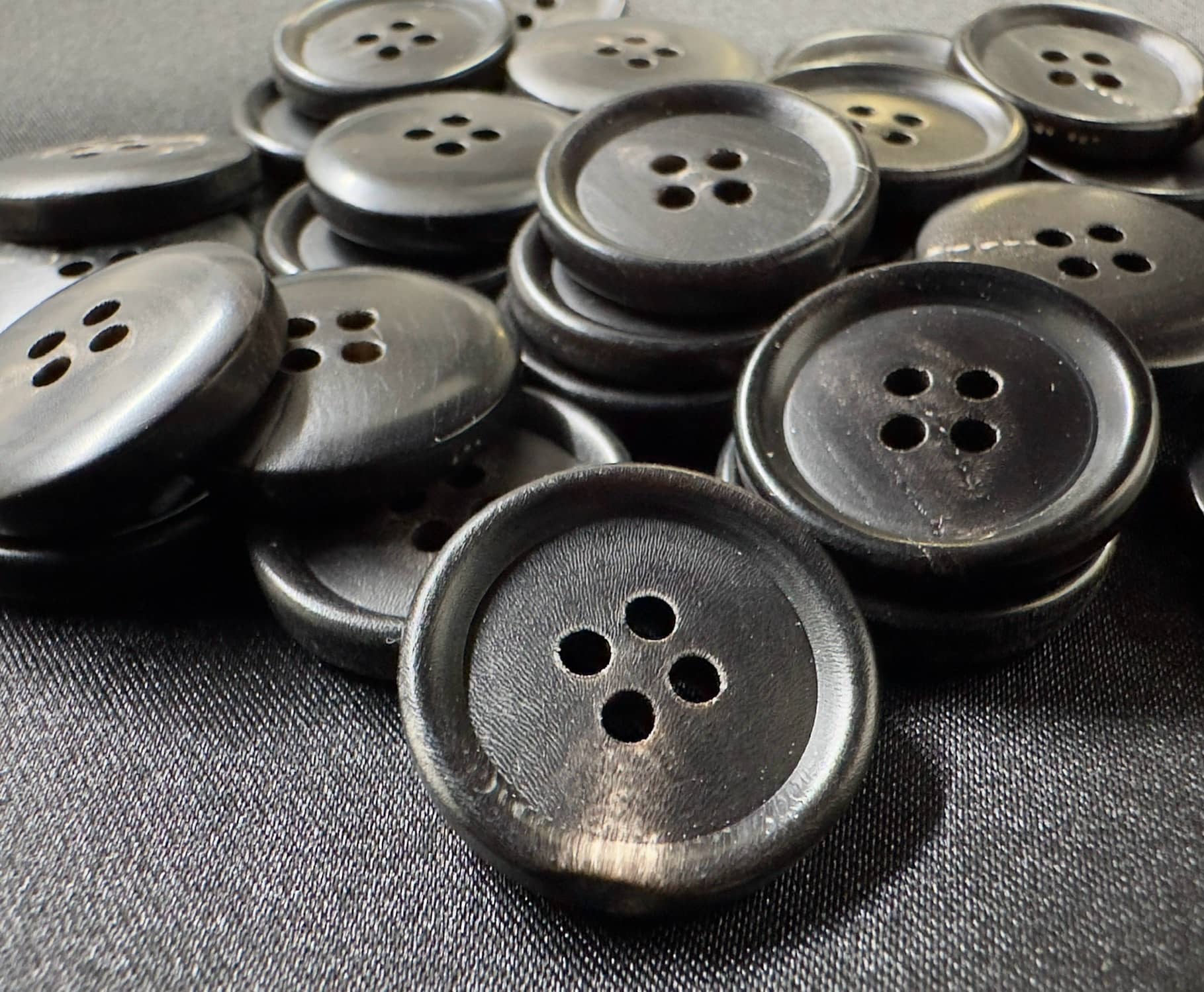 Premium horn sewing button by Buttonology Inc made of dark polished horn with four holes for sewing
