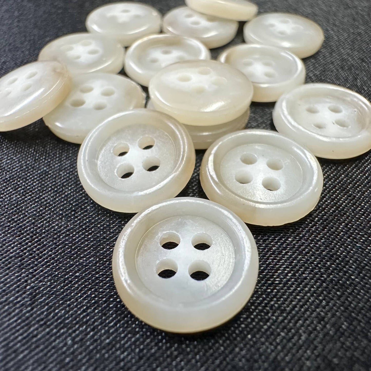 Collection of premium sewing buttons for clothes in a shiny finish, featuring different hole configurations