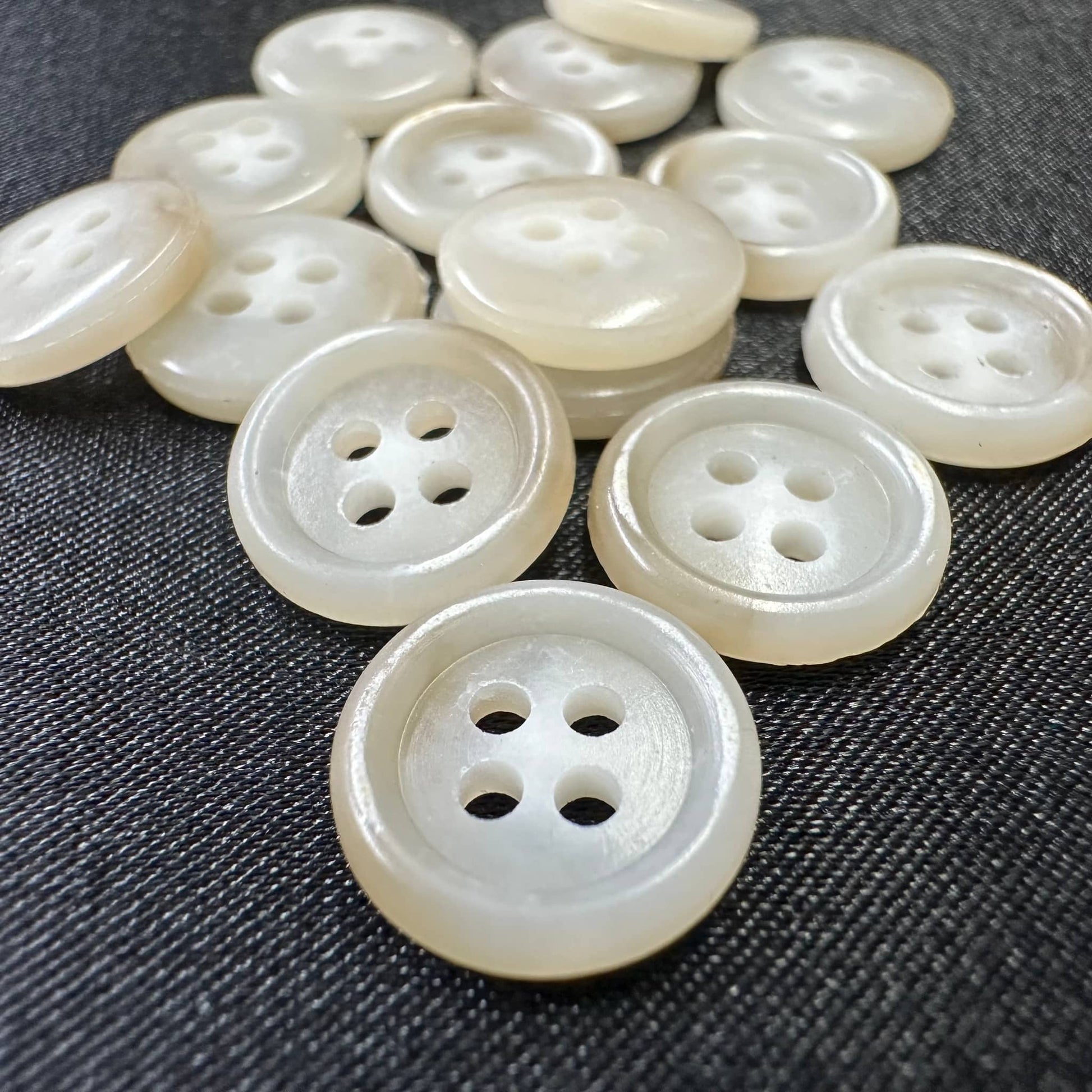 Collection of premium sewing buttons for clothes in a shiny finish, featuring different hole configurations