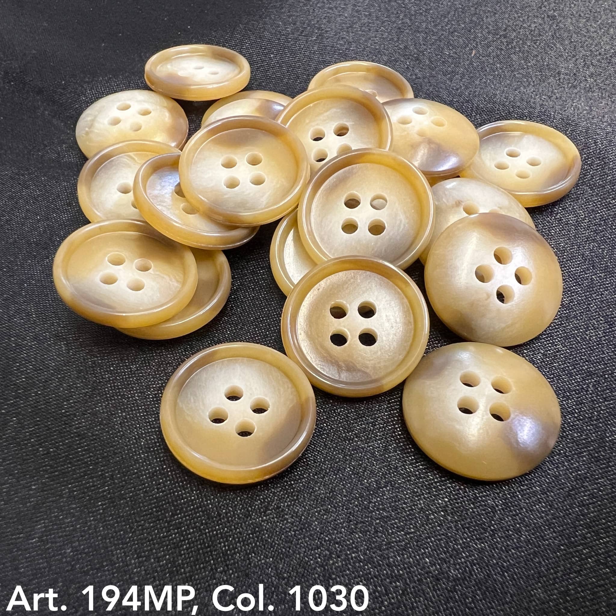 Buttonology Inc premium suit buttons in beige with four holes on black fabric background
