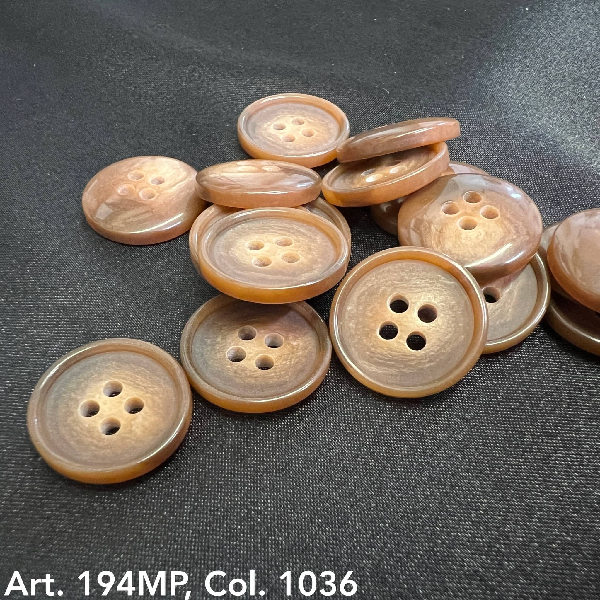 Buttonology Inc premium suit buttons in brown with four holes displayed on black fabric