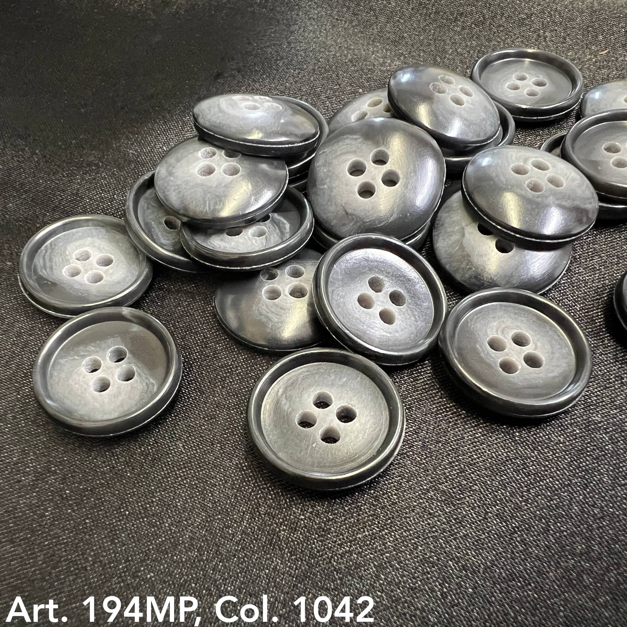 Buttonology Inc premium suit buttons in sleek gray with four holes stacked on black fabric