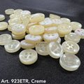 Assorted sew-on buttons for clothing in creamy tones with four holes for easy attachment