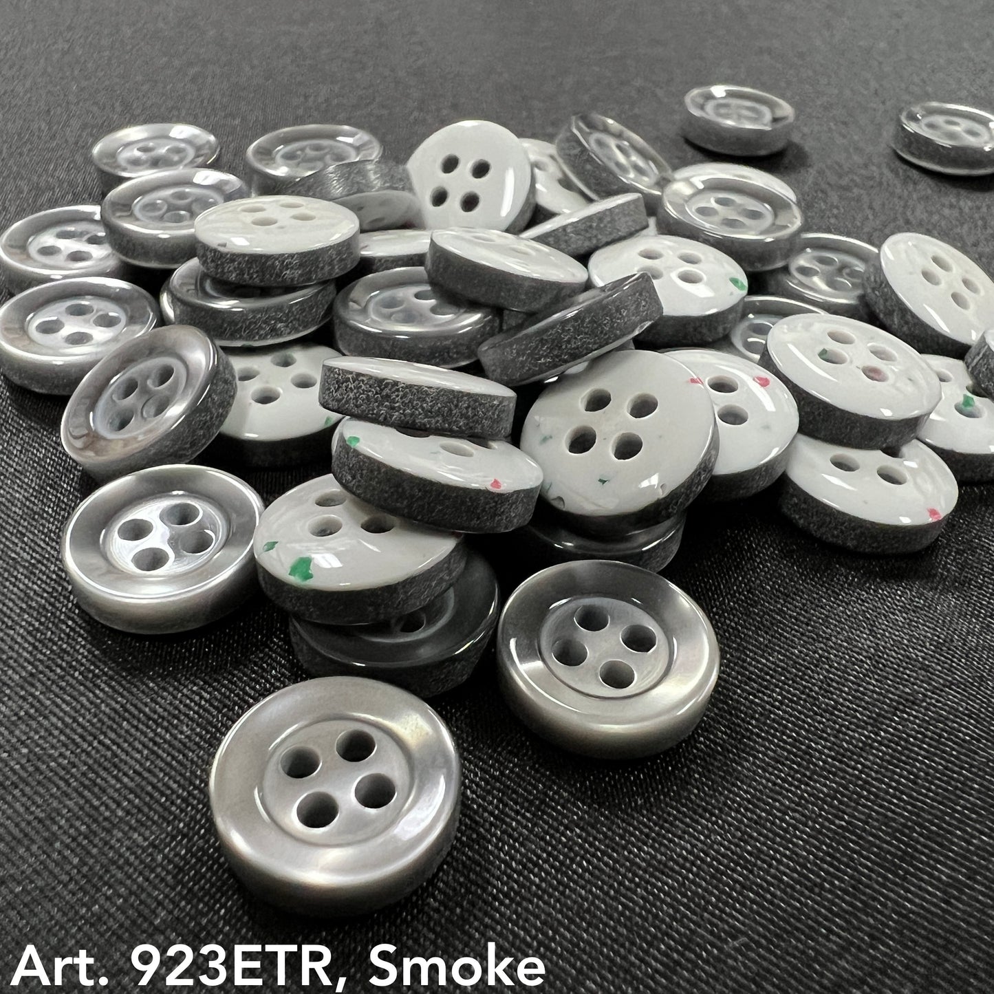 Assorted sew-on buttons for clothing in smoke color, featuring a shiny finish and two holes