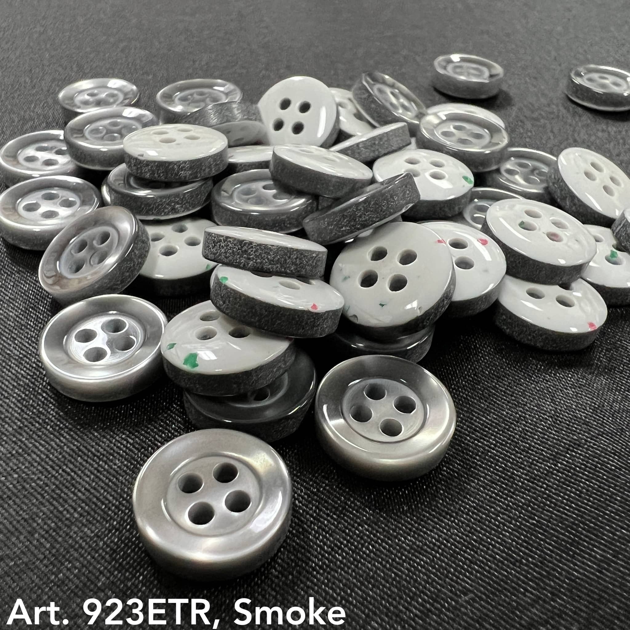 Assorted sew-on buttons for clothing in smoke color, featuring a shiny finish and two holes