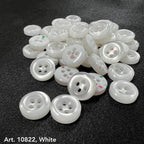 White sewing accessory buttons from Buttonology Inc with four holes on black fabric background