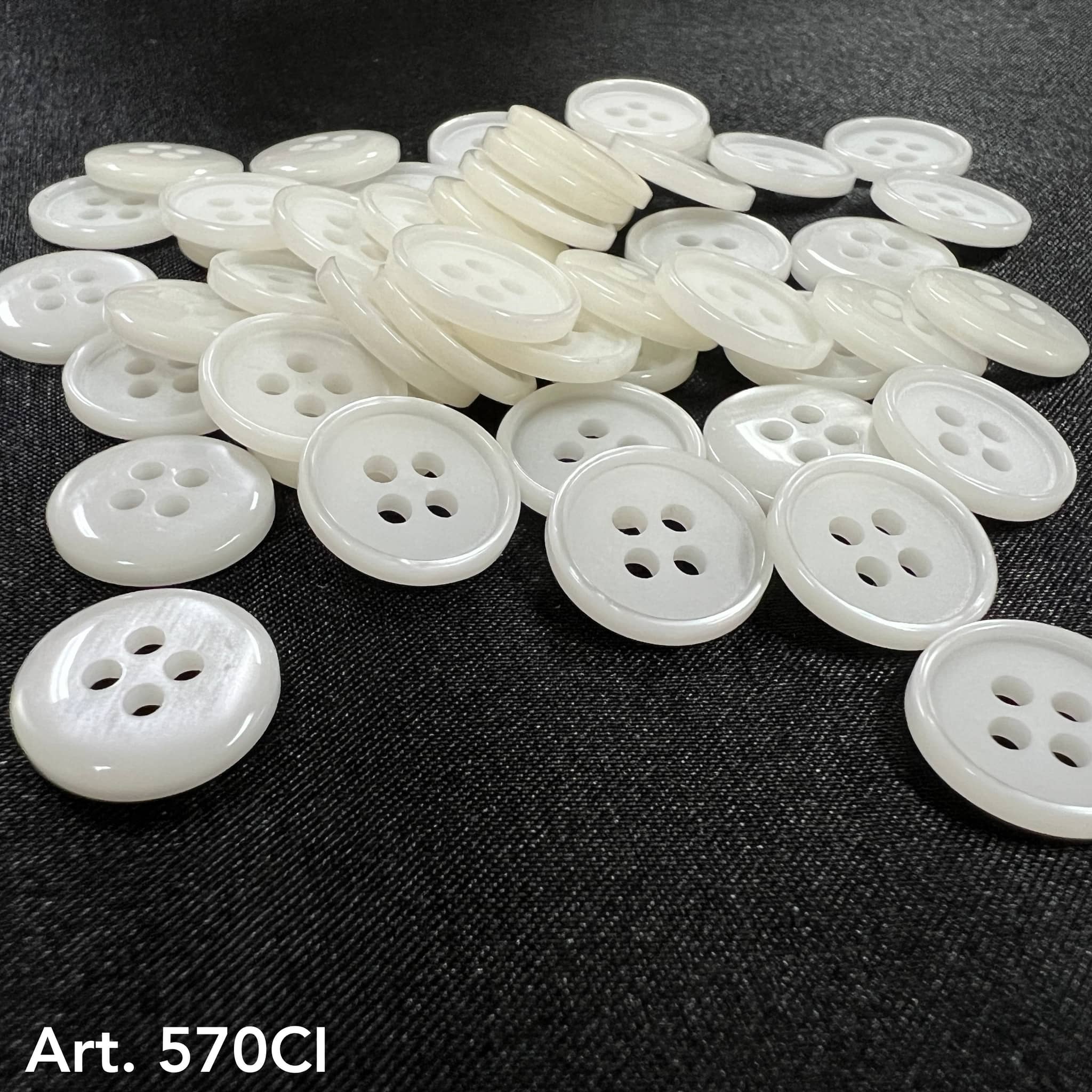 A collection of white sewing buttons with four holes for crafting and garment repairs