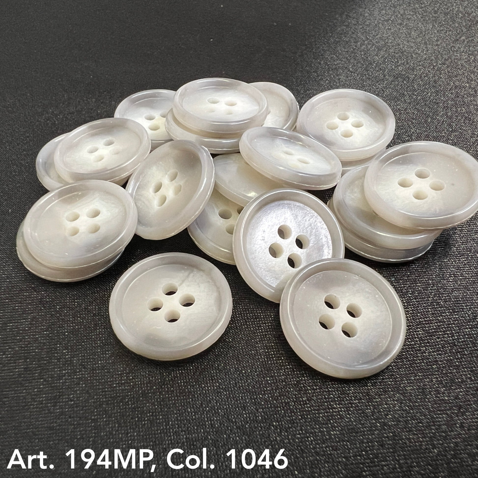 Shirting buttons for dress shirts in a variety of light colors, showcasing four holes for easy stitching