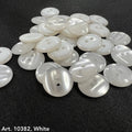 White smoke design buttons for accessories by Buttonology Inc piled on black fabric