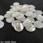 White smoke design buttons for accessories by Buttonology Inc piled on black fabric