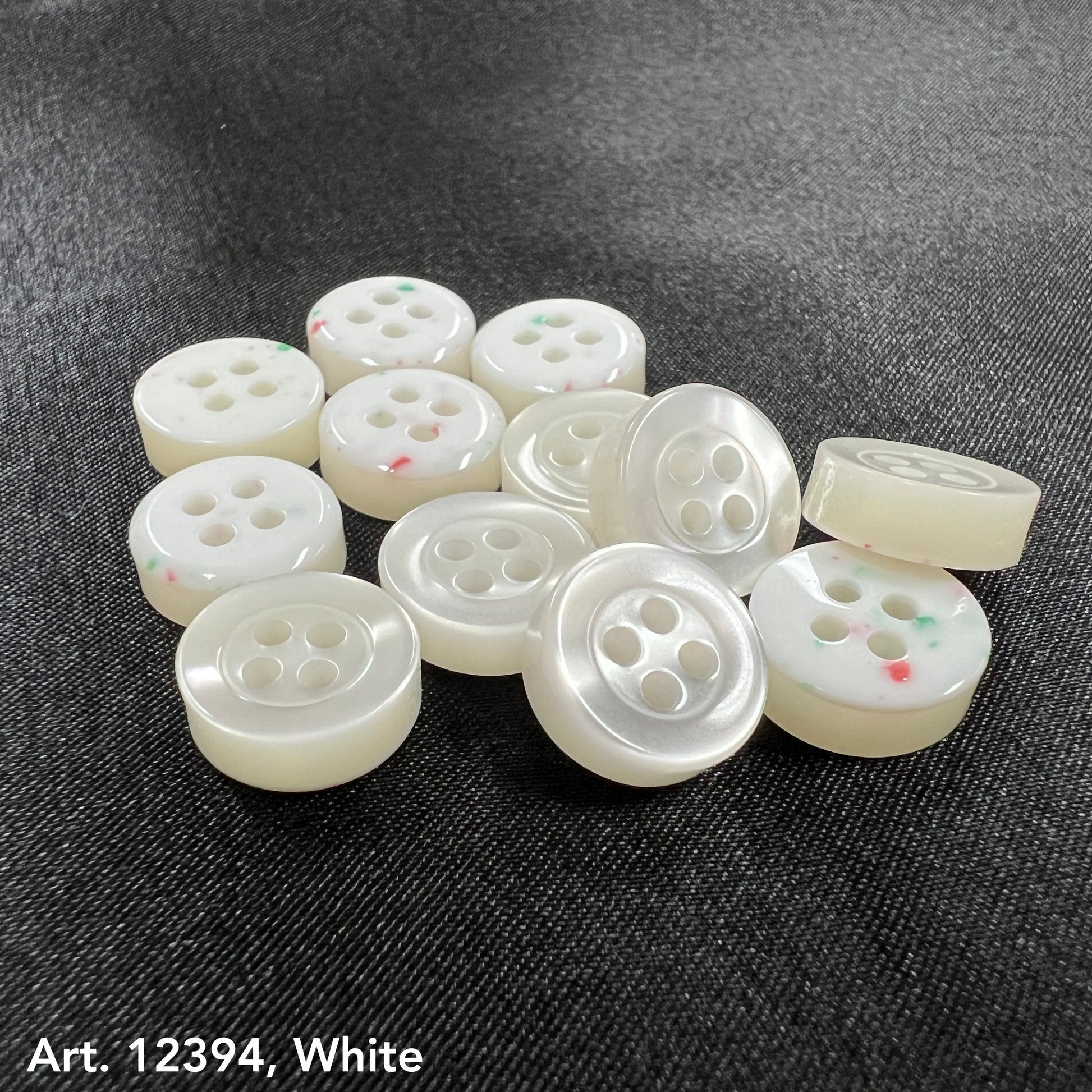 White garment buttons from Buttonology Inc on smoke gray garment buttons background