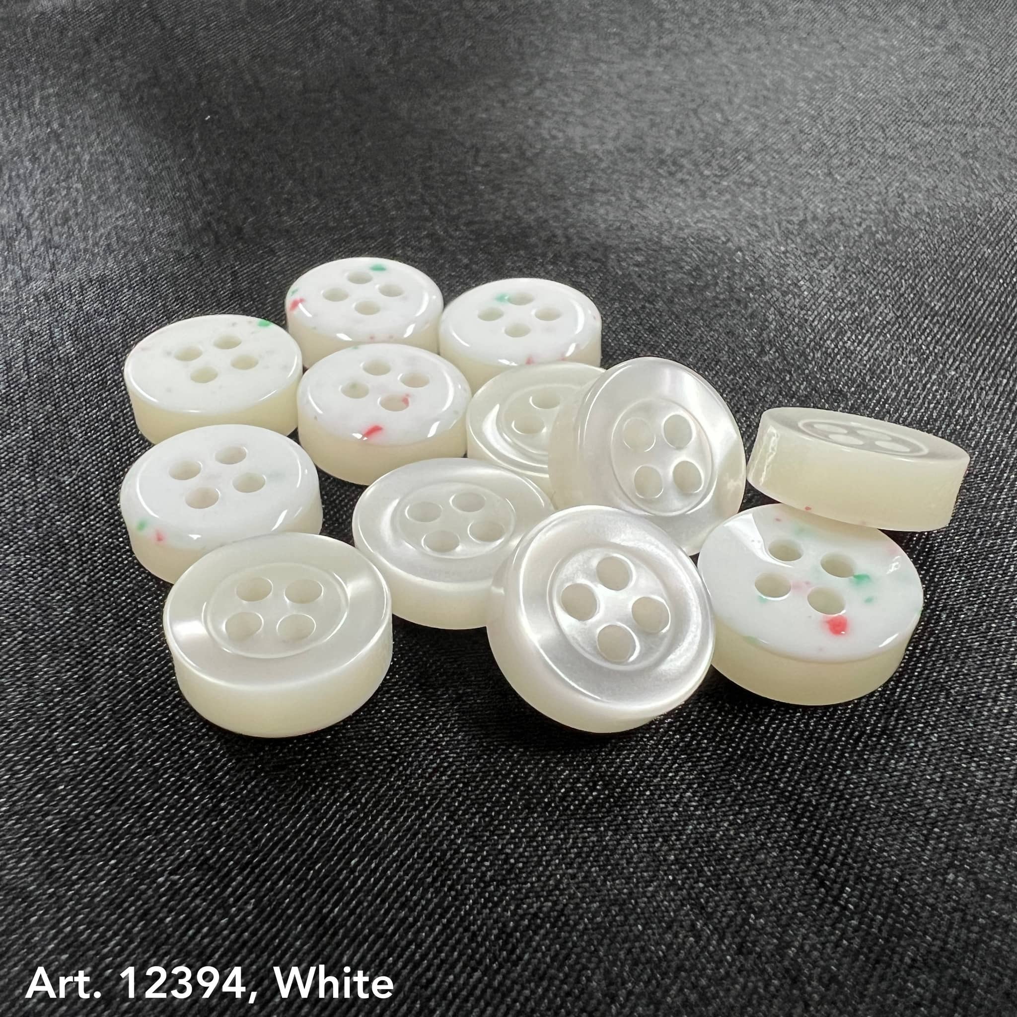 White garment buttons from Buttonology Inc on smoke gray garment buttons background