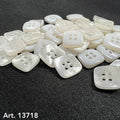 Square Shaped Sewing Buttons in white pearl finish scattered on black fabric background