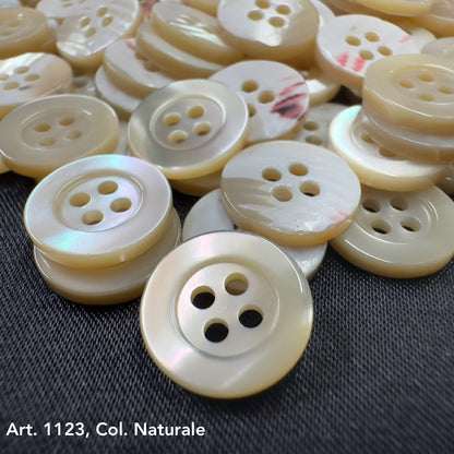 Troca shell buttons by Buttonology Inc in natural color with four holes on black fabric background