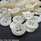 Close-up of white and cream Troca shell buttons with four holes from Buttonology Inc.