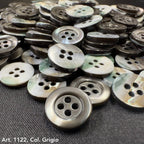 Close-up of Troca shell buttons by Buttonology Inc with a gray and iridescent finish, perfect for sewing projects