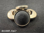 Buttonology Inc black Urea shank buttons with a smooth finish arranged on black fabric